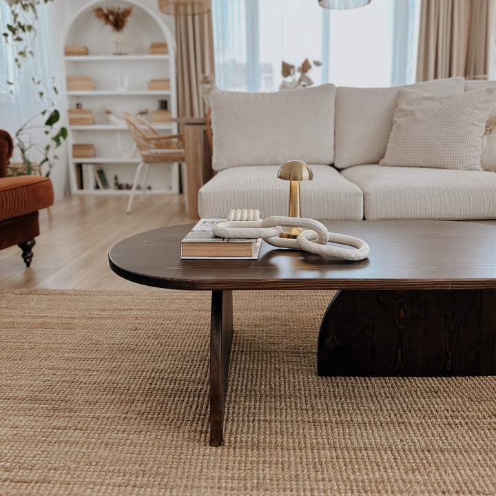 Living room with a beige sofa, wooden coffee table, and decorative items.