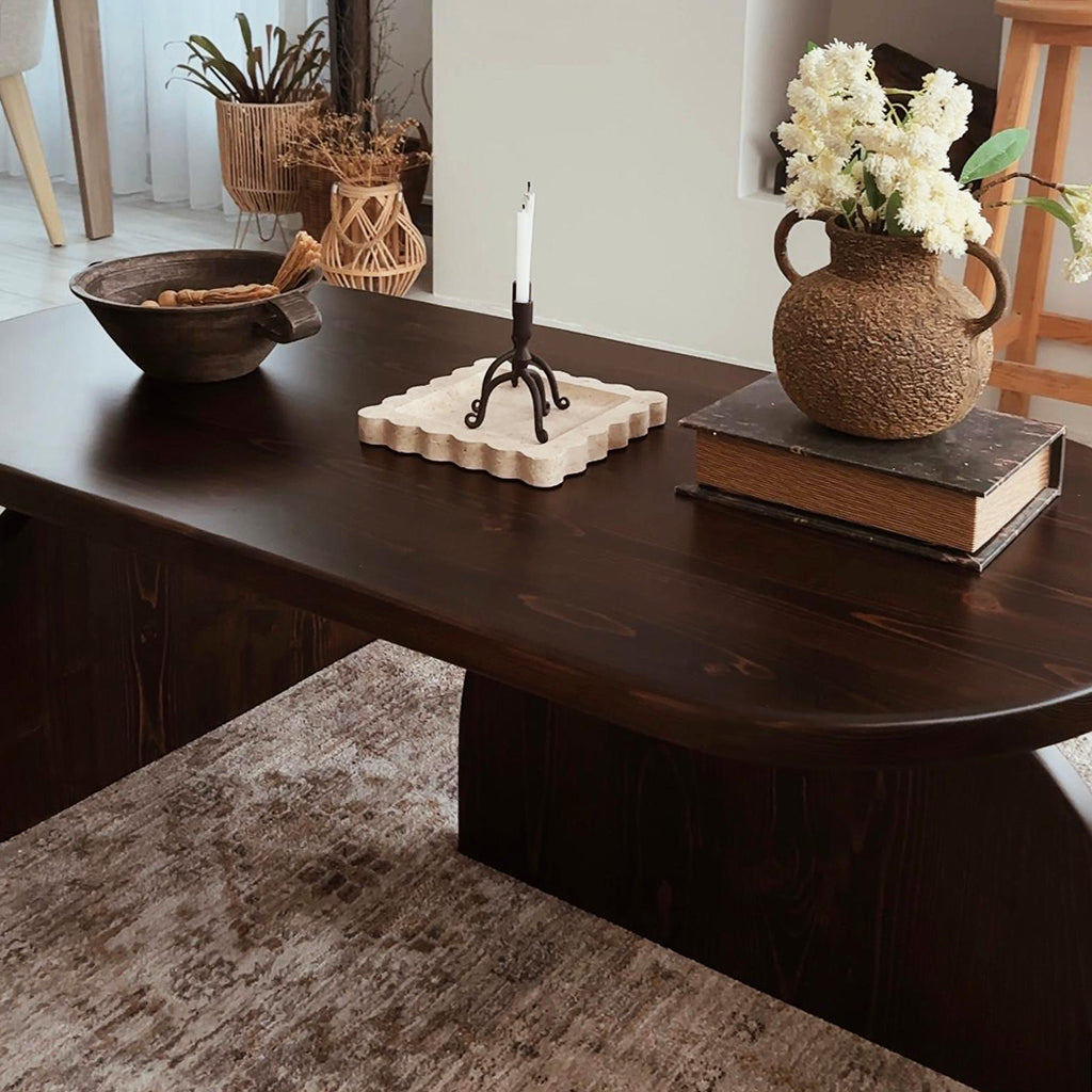 Low close-up of the dark brown oval table top edge and base