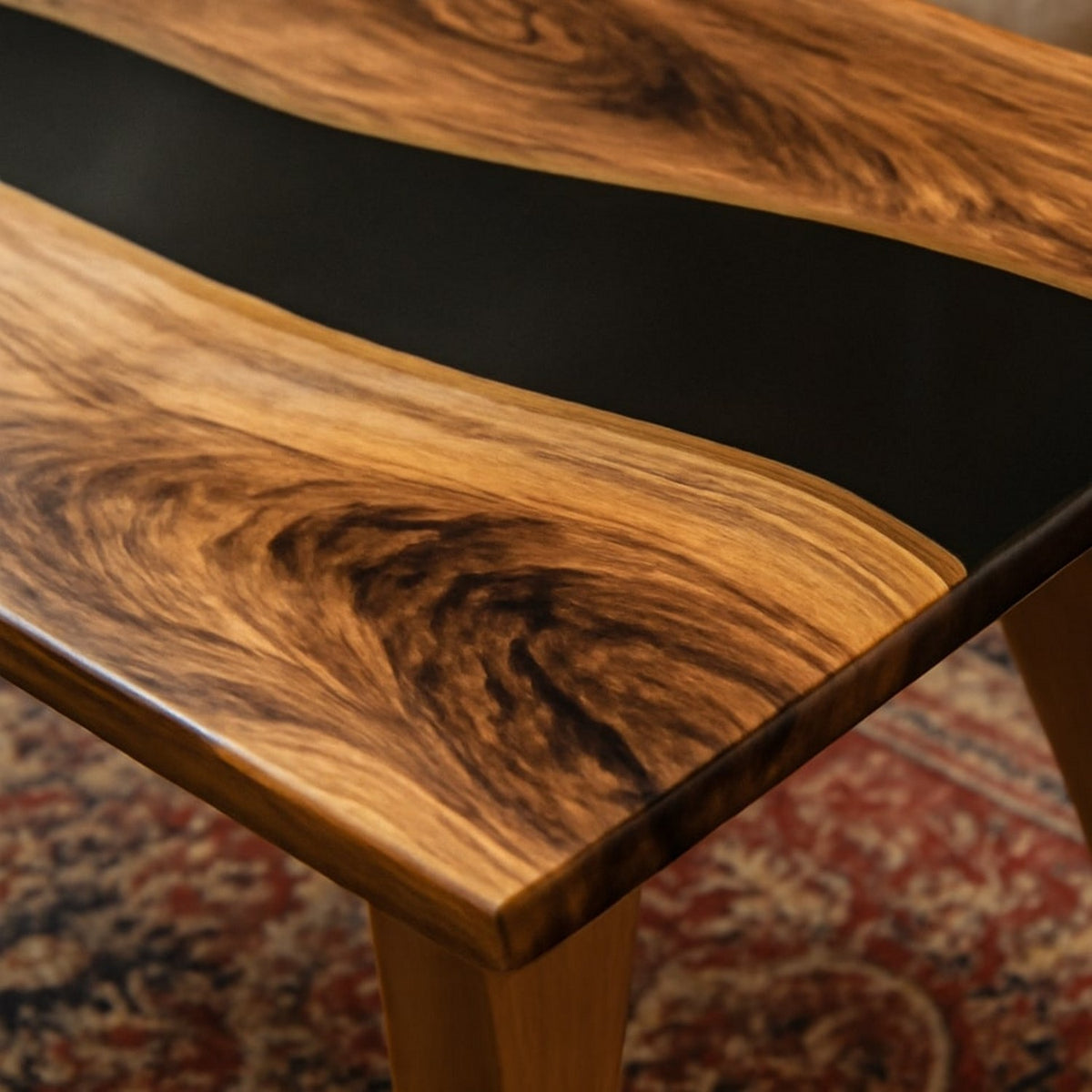 Close-up of the walnut grain and black epoxy river at the corner of the live edge coffee table