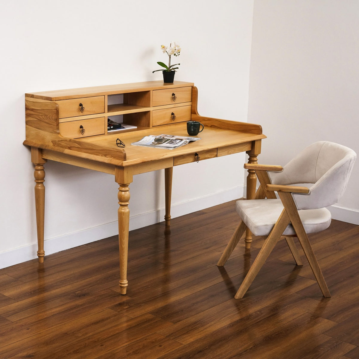 Wide view of the beech writing desk with hutch and turned legs, an upholstered chair beside it