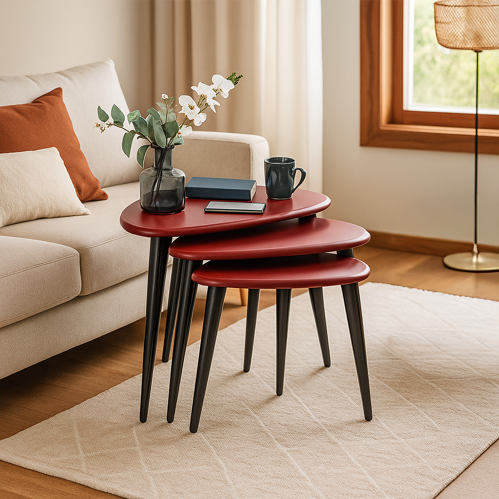 Set of three red nesting tables in a living room setting with a couch and decor items.