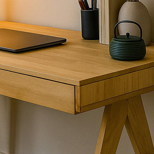 Wooden desk with a black teapot and pen holder on a neutral background