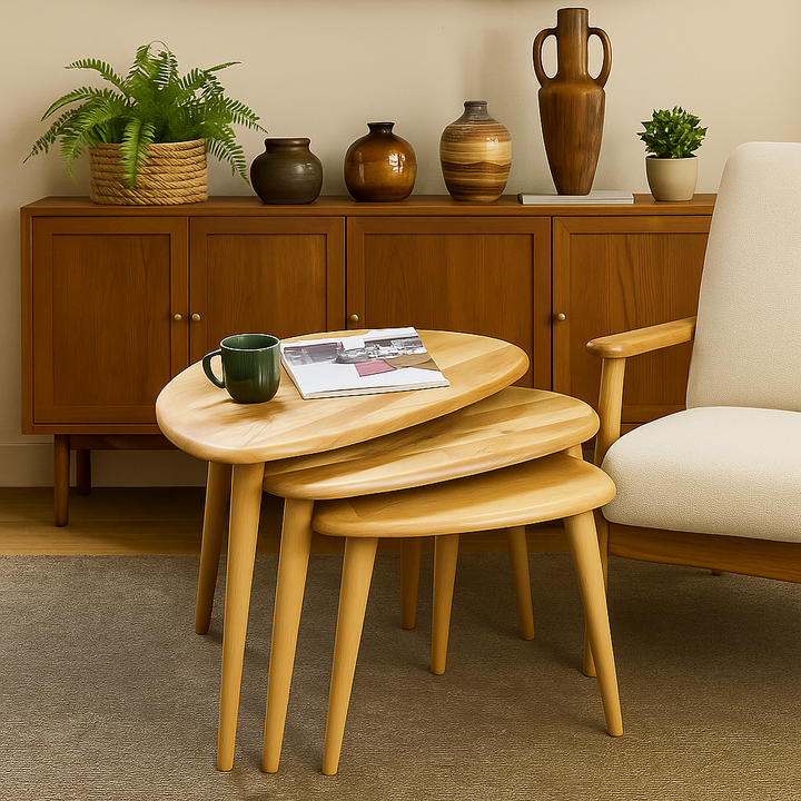 Wooden nesting tables with a mug and newspaper in front of a wooden cabinet with decorative items.