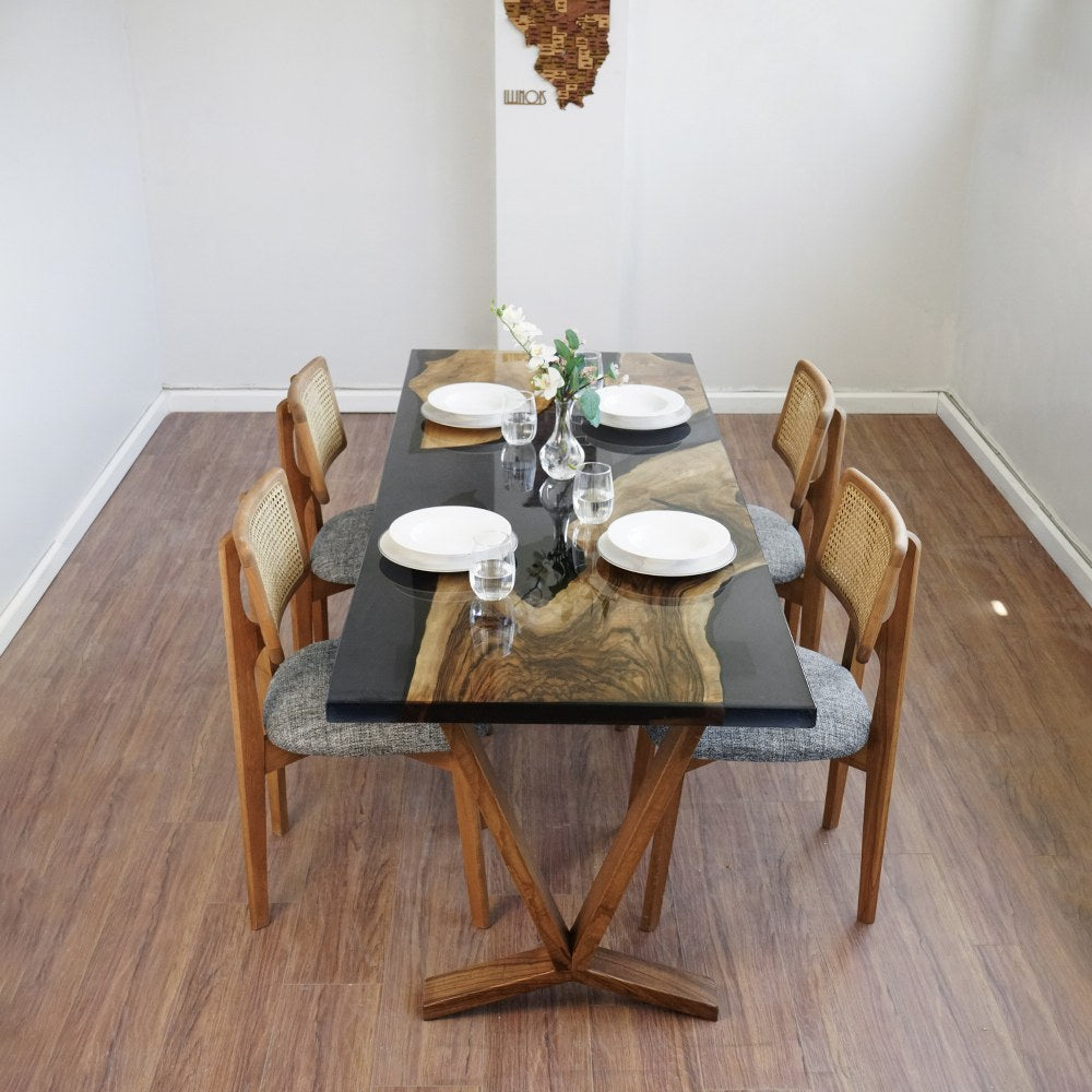 End view of the live edge black epoxy dining table with chairs along both long sides
