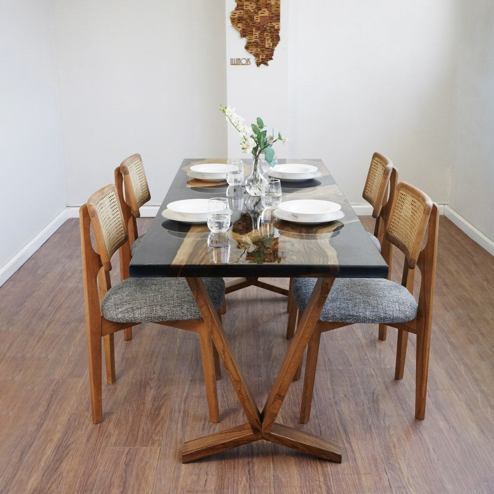 Straight front view of the Obsidian dining table with the V shaped wooden base and chairs