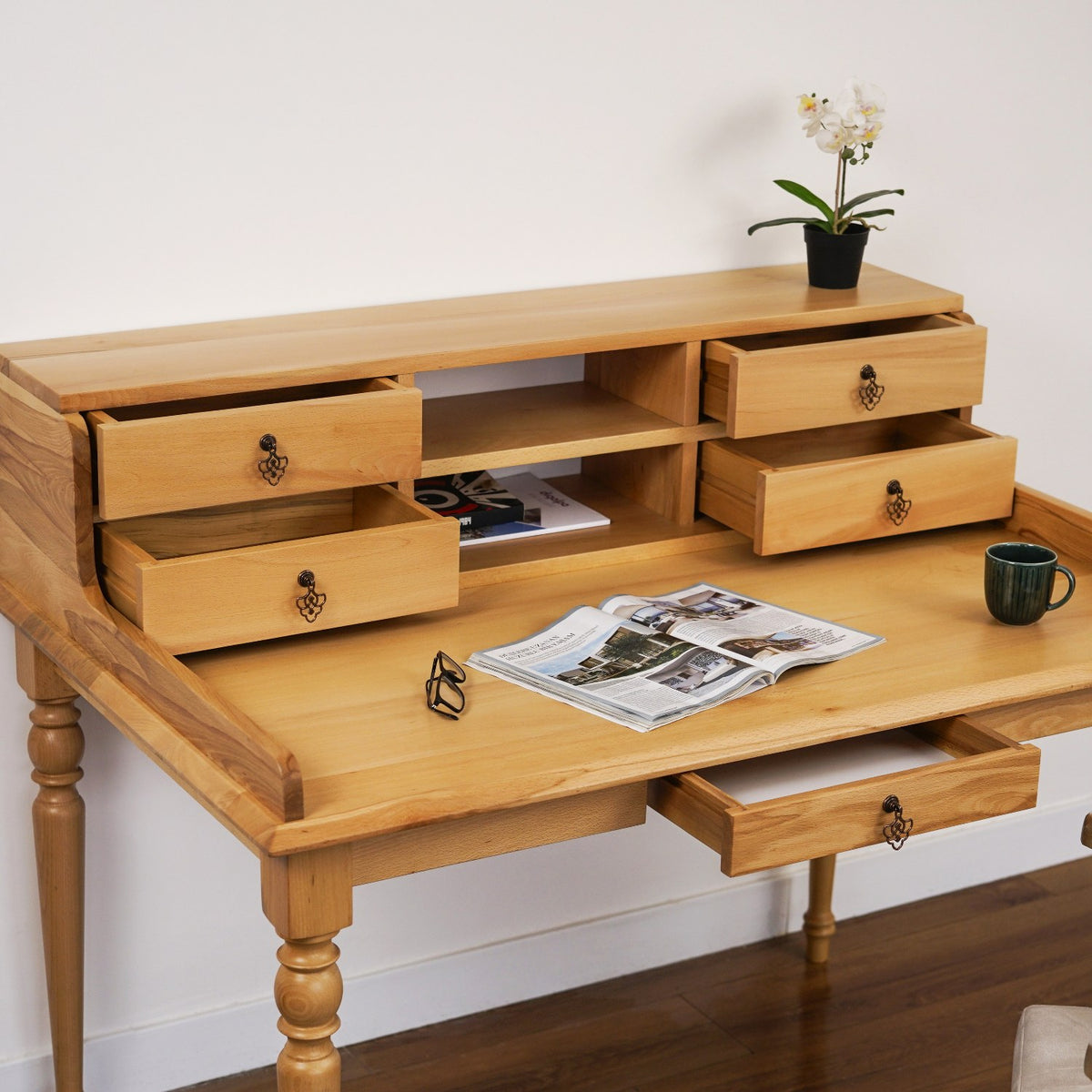 Beech writing desk with hutch drawers and the center drawer pulled open, with a magazine on top