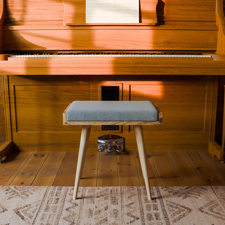 Wooden piano with a stool on a wooden floor