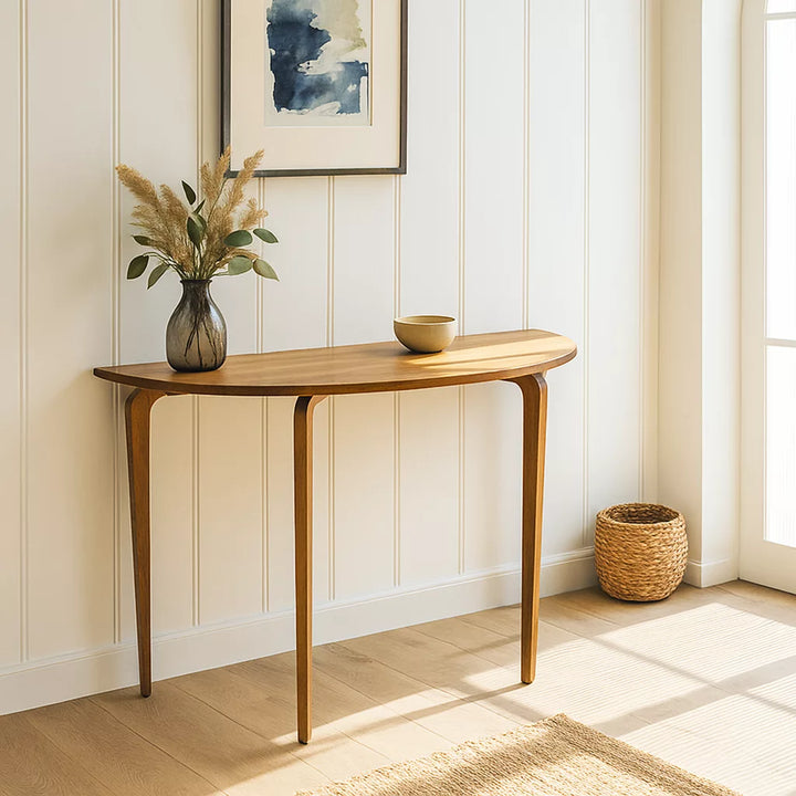 A wooden round entryway table set against white walls, enhancing the room's clean and modern aesthetic.