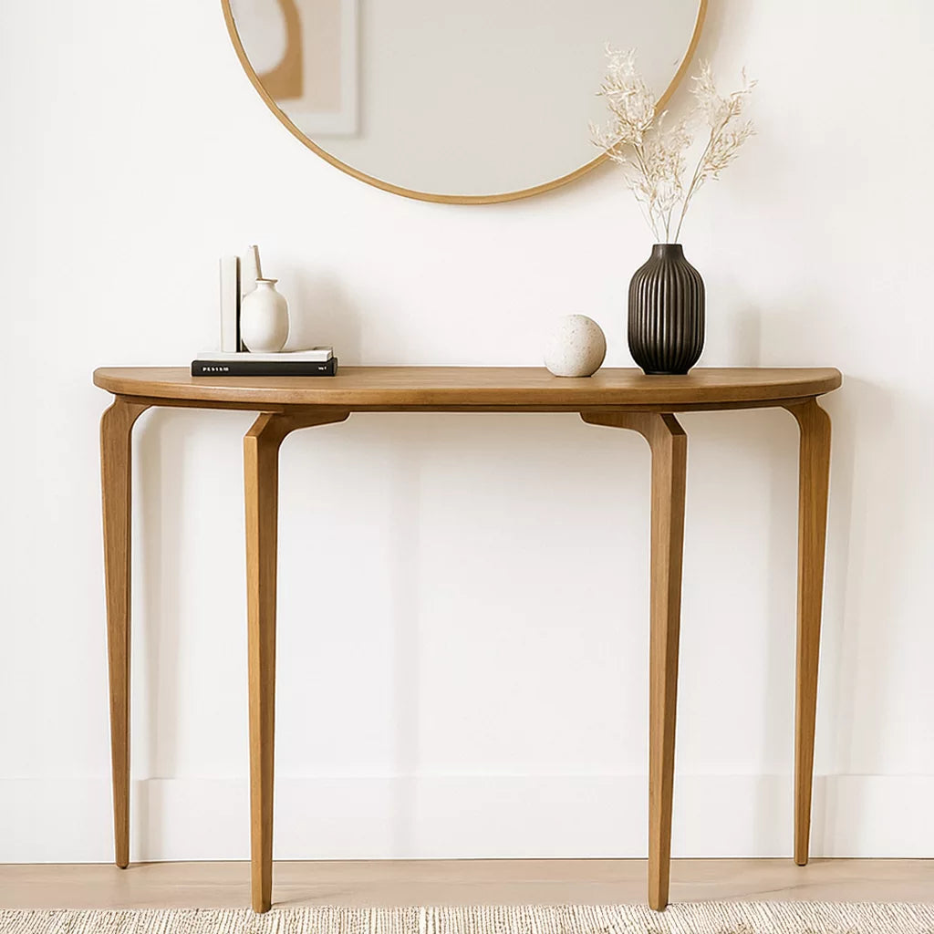 Half-round walnut console table with three tapered legs under a round mirror, front view