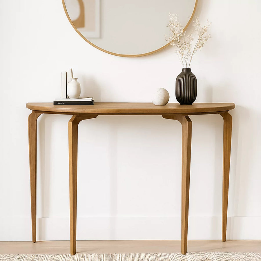 Half-round walnut console table with three tapered legs under a round mirror, front view