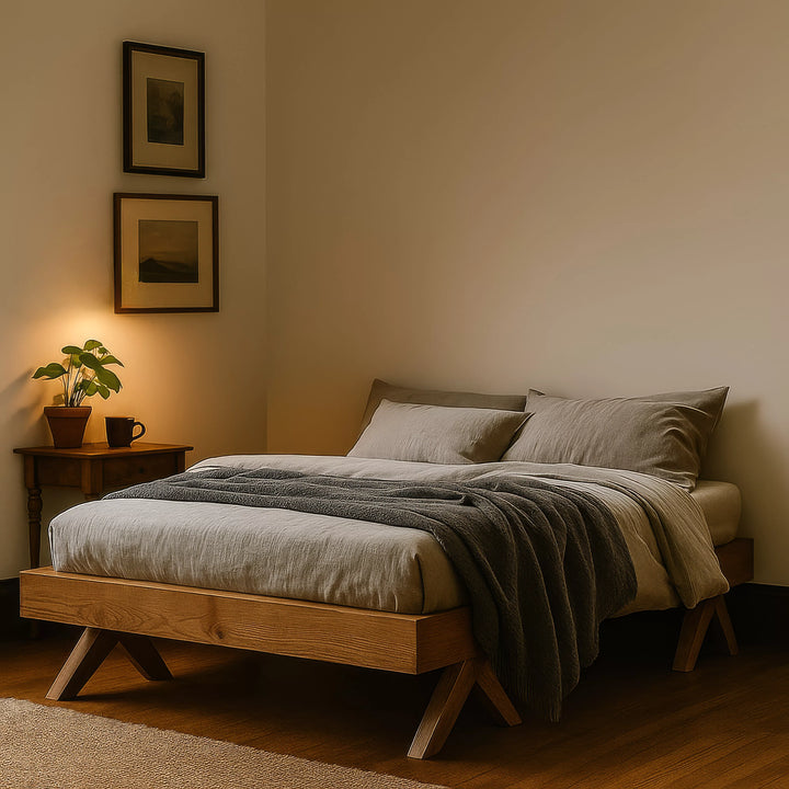 A wooden Scandinavian bed frame featuring a light gray blanket, offering a minimalist and stylish bedroom aesthetic.