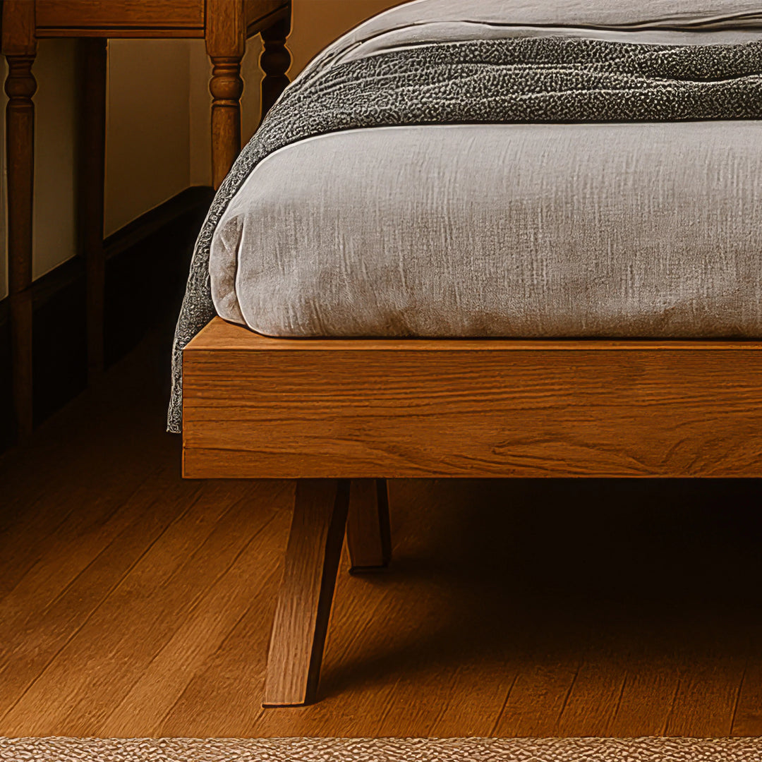 A Scandinavian bed frame adorned with a blanket, accompanied by a nightstand, showcasing a modern bedroom aesthetic.