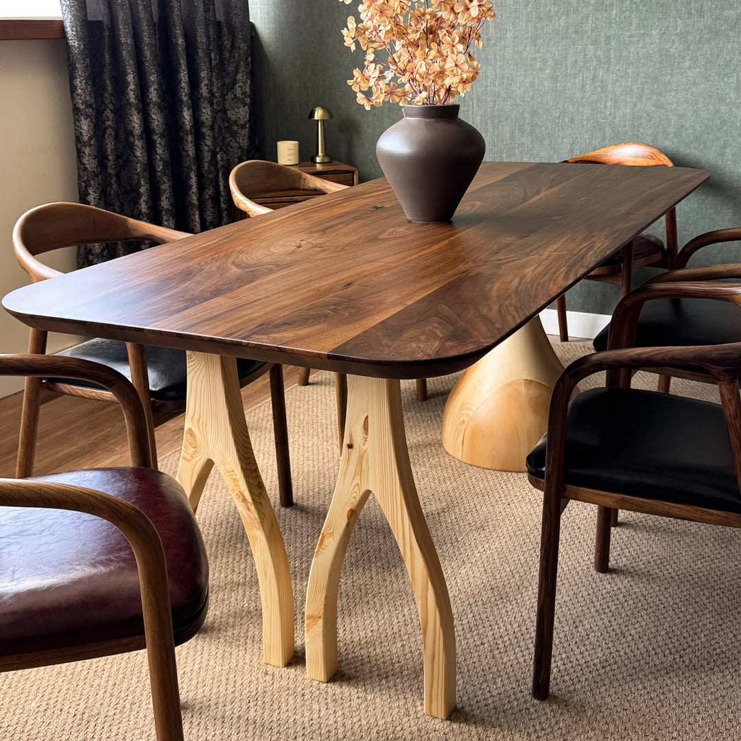 Sculptural dining table — solid walnut top with handcrafted linden wood legs in organic forms