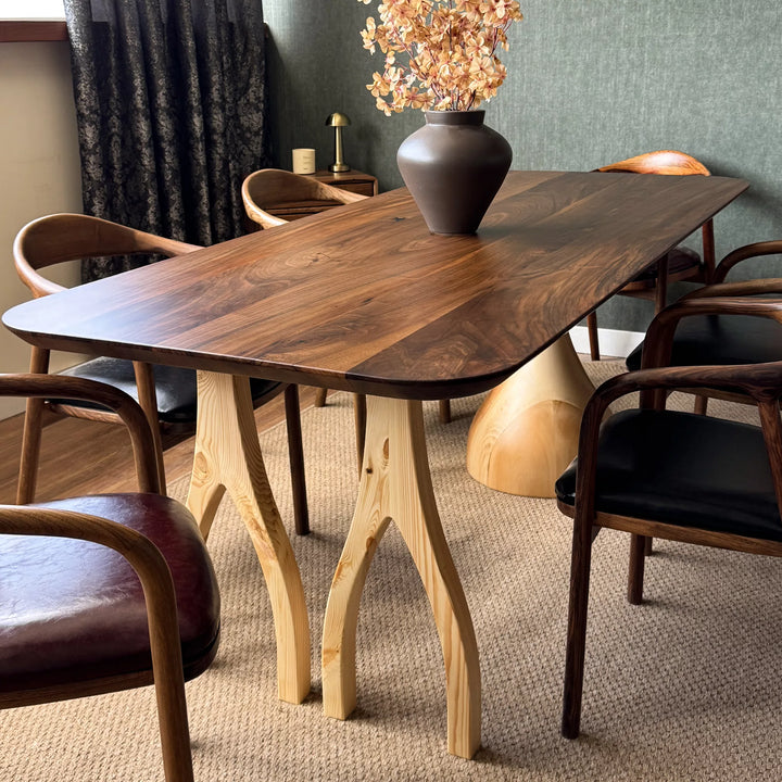 Sculptural dining table — solid walnut top with handcrafted linden wood legs in organic forms