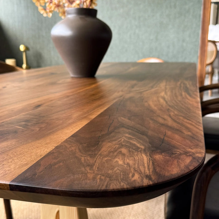 Sculptural dining table — solid walnut top with handcrafted linden wood legs in organic forms