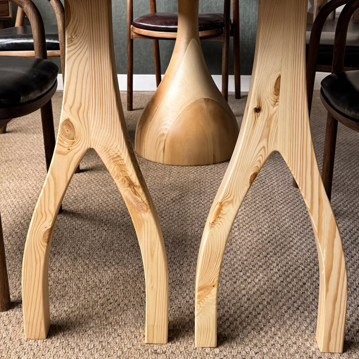 Sculptural dining table — solid walnut top with handcrafted linden wood legs in organic forms