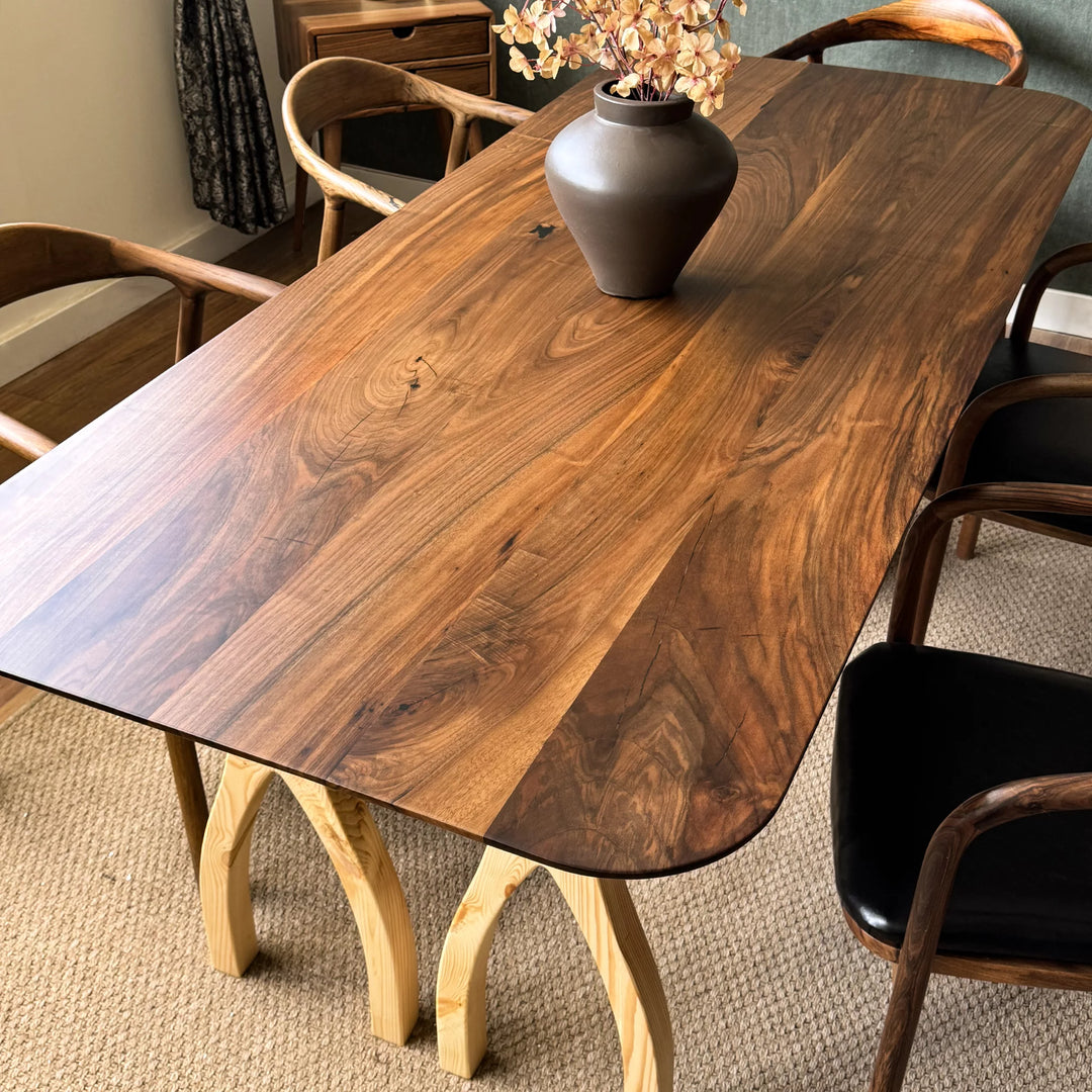 Sculptural dining table — solid walnut top with handcrafted linden wood legs in organic forms