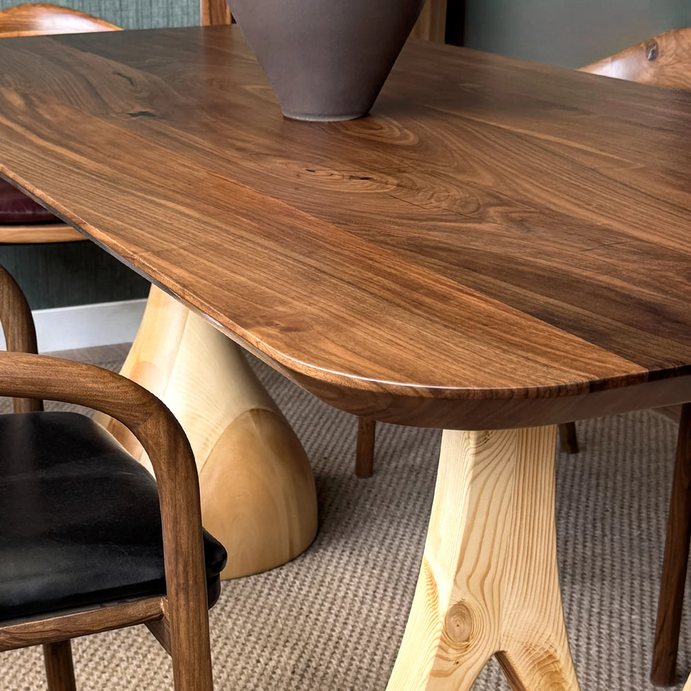 Sculptural dining table — solid walnut top with handcrafted linden wood legs in organic forms
