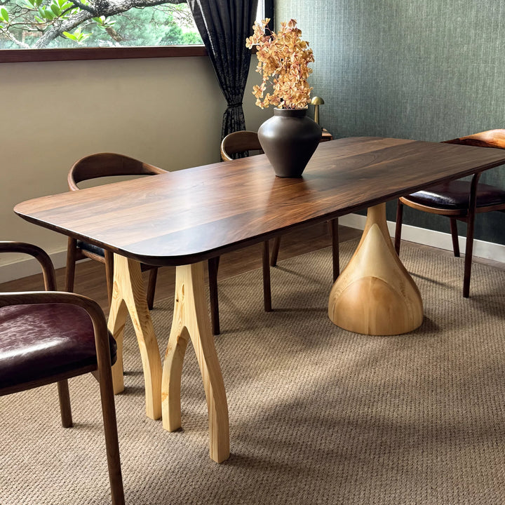 Sculptural dining table — solid walnut top with handcrafted linden wood legs in organic forms