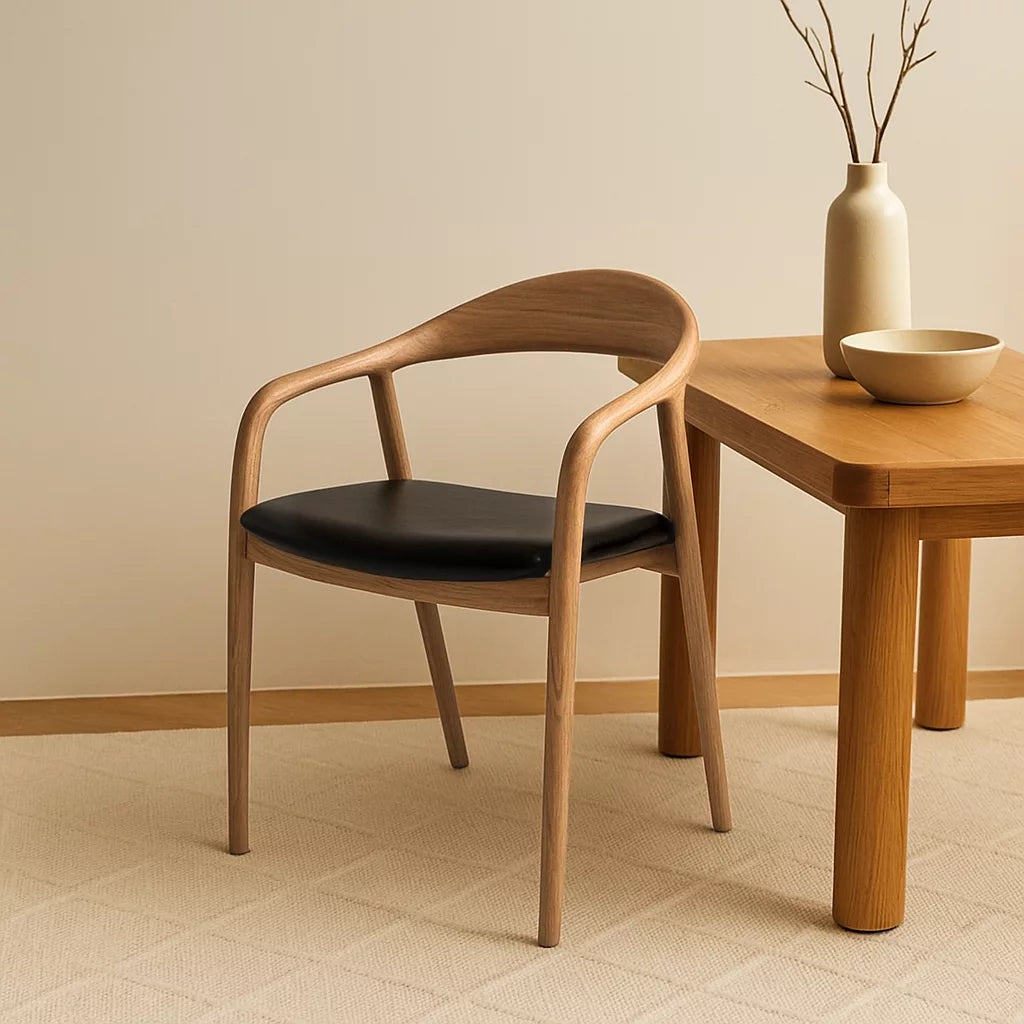 Solid wood beech dining chair with black leather cushion beside a table and a vase in a cozy room setting.