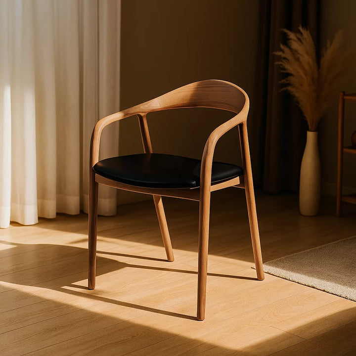Solid wood beech dining chair with a black leather cushion, positioned in a room featuring a window.