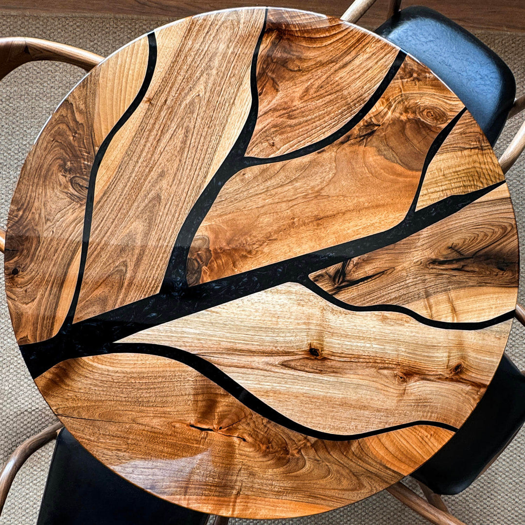 Sophisticated tree pattern walnut table detailed with branching epoxy infills, styled with a minimalist ceramic vase and pampas grass.