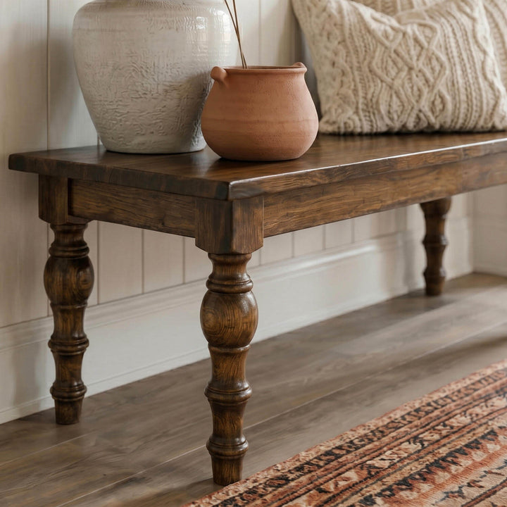 Classic turned leg wooden bench positioned against vertical shiplap wall paneling next to a patterned area rug.