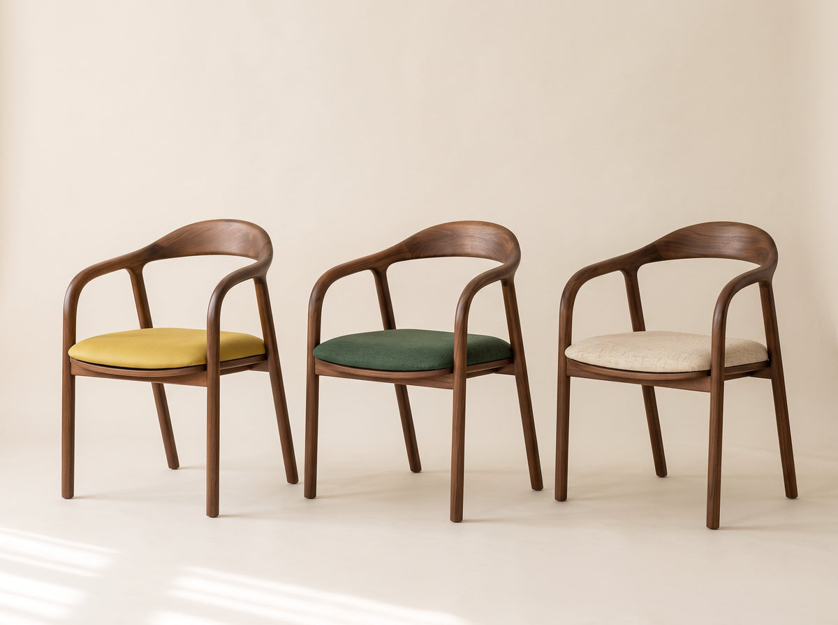 Three walnut dining chairs with mustard, green and cream seat fabric