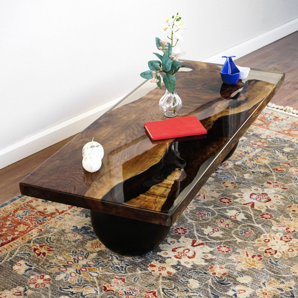 Walnut epoxy coffee table top seen at a raised angle, showing the dark river and live edge