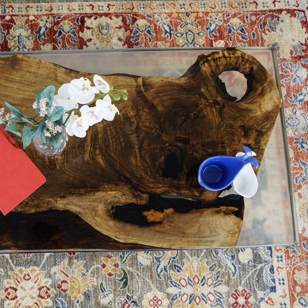 Top view of the walnut live edge slab with clear epoxy and a knot hole on the coffee table