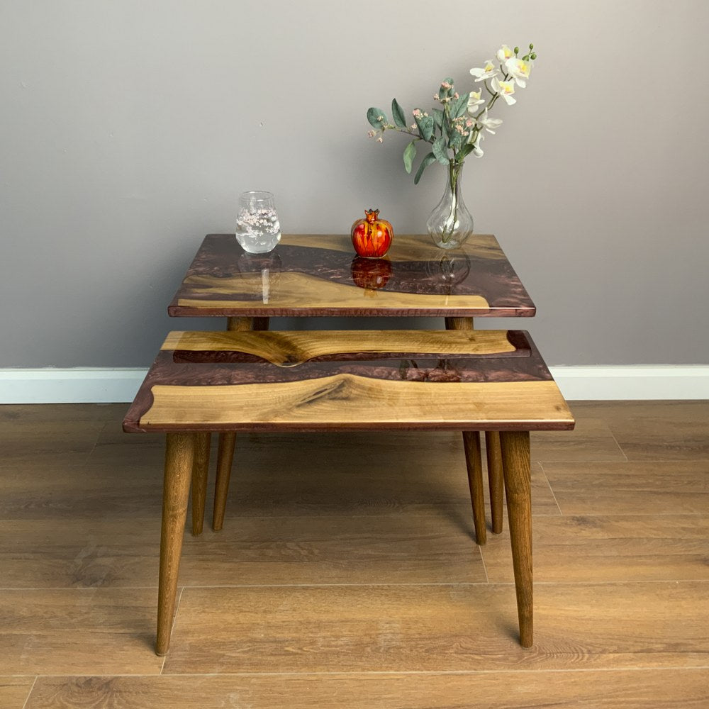 Front view of the walnut nesting tables, small table tucked under the large one with a burgundy river