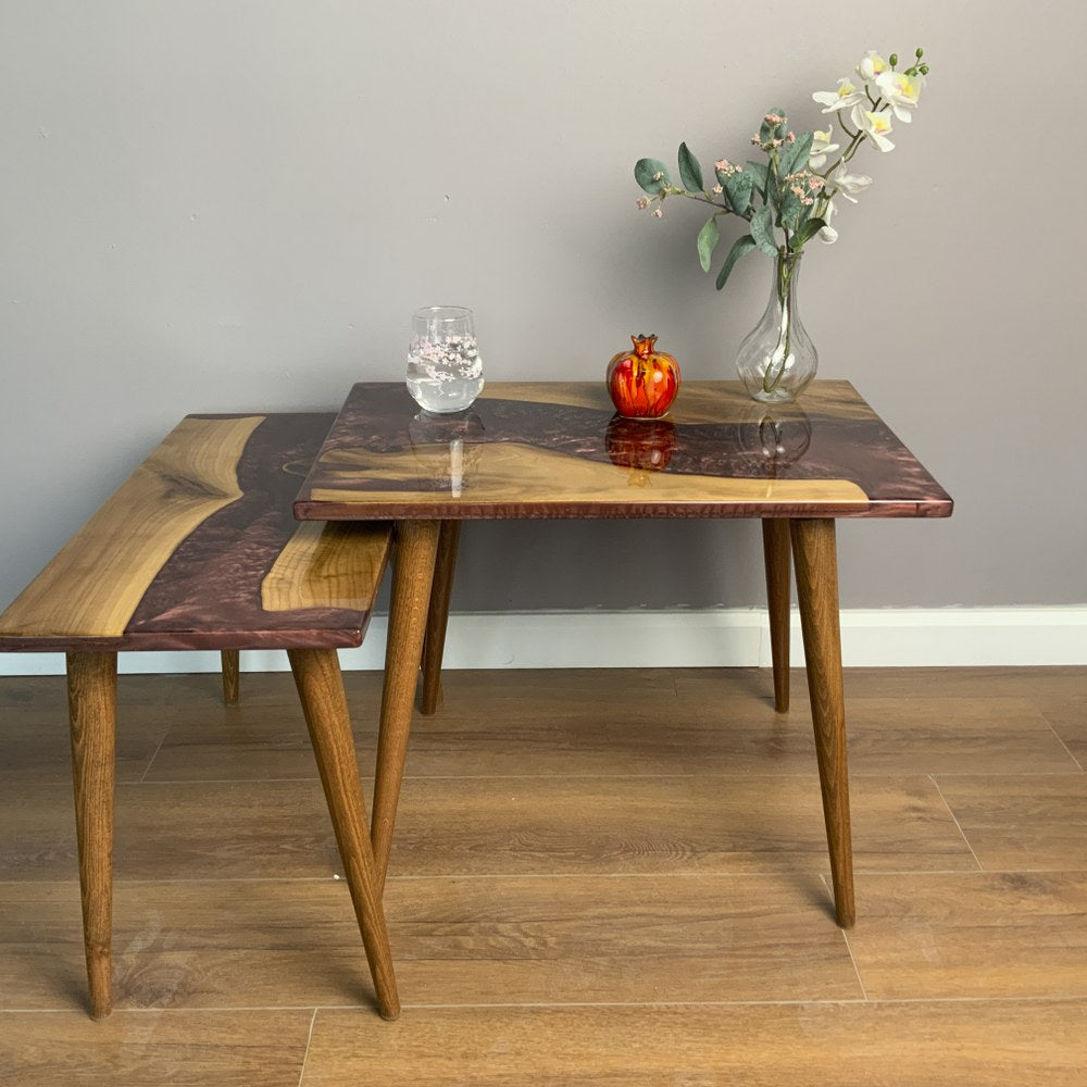 Large walnut nesting table with a burgundy epoxy river, small table pulled out at the left, side view