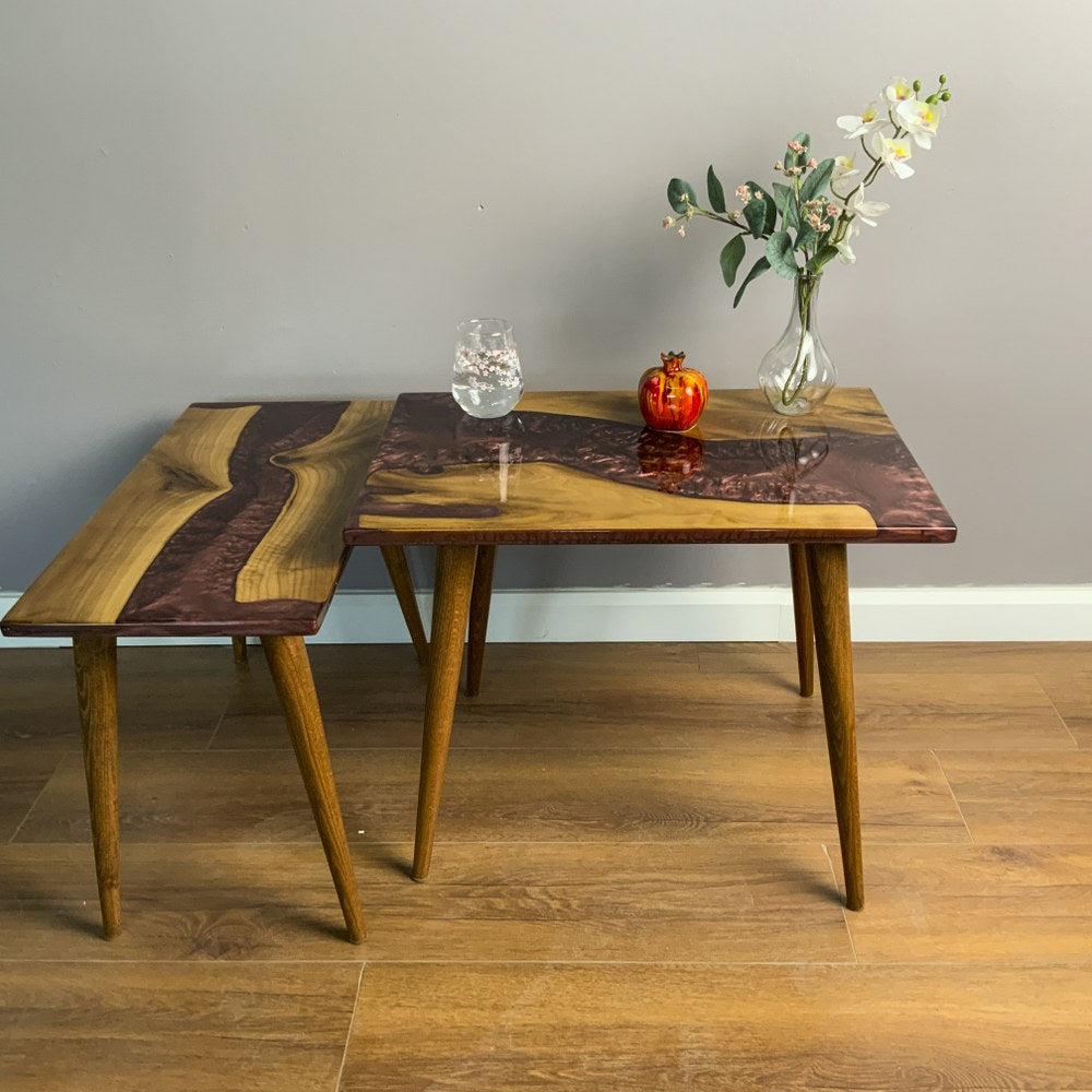 Large walnut nesting table with burgundy epoxy river and the small table partly pulled out on the left