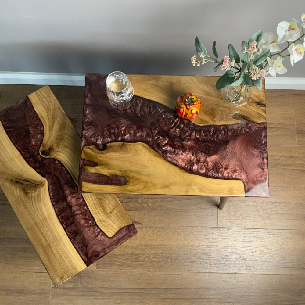 Walnut nesting tables from above with the small table pulled out to the left, showing the burgundy epoxy