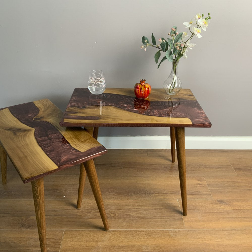 Walnut nesting tables with the small table pulled out to the left, burgundy epoxy river on both tops