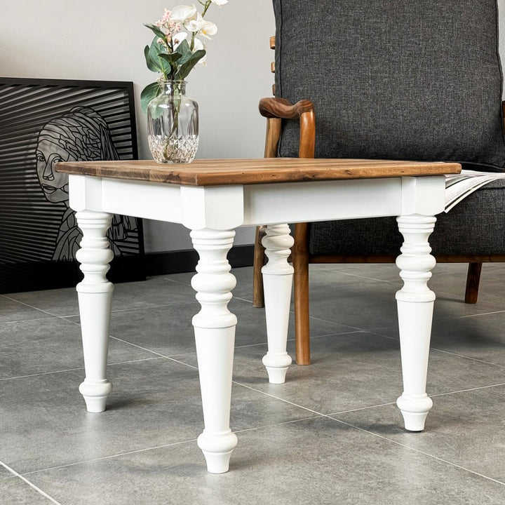Low angle of the white turned legs and walnut top of the farmhouse side table