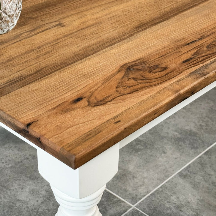 Close-up of walnut grain on the side table top with the white painted leg below