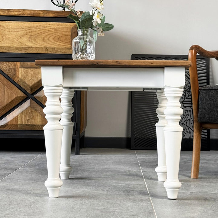 Front view of the walnut side table showing the white apron and turned legs