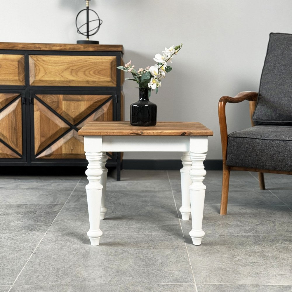 Wide view of the side table with walnut top and white legs in front of a sideboard