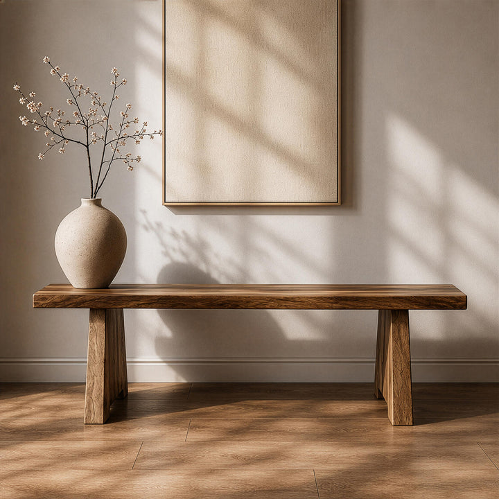 Walnut wood bench crafted from a solid timber slab, styled with a minimalist spherical ceramic vase in a serene setting.