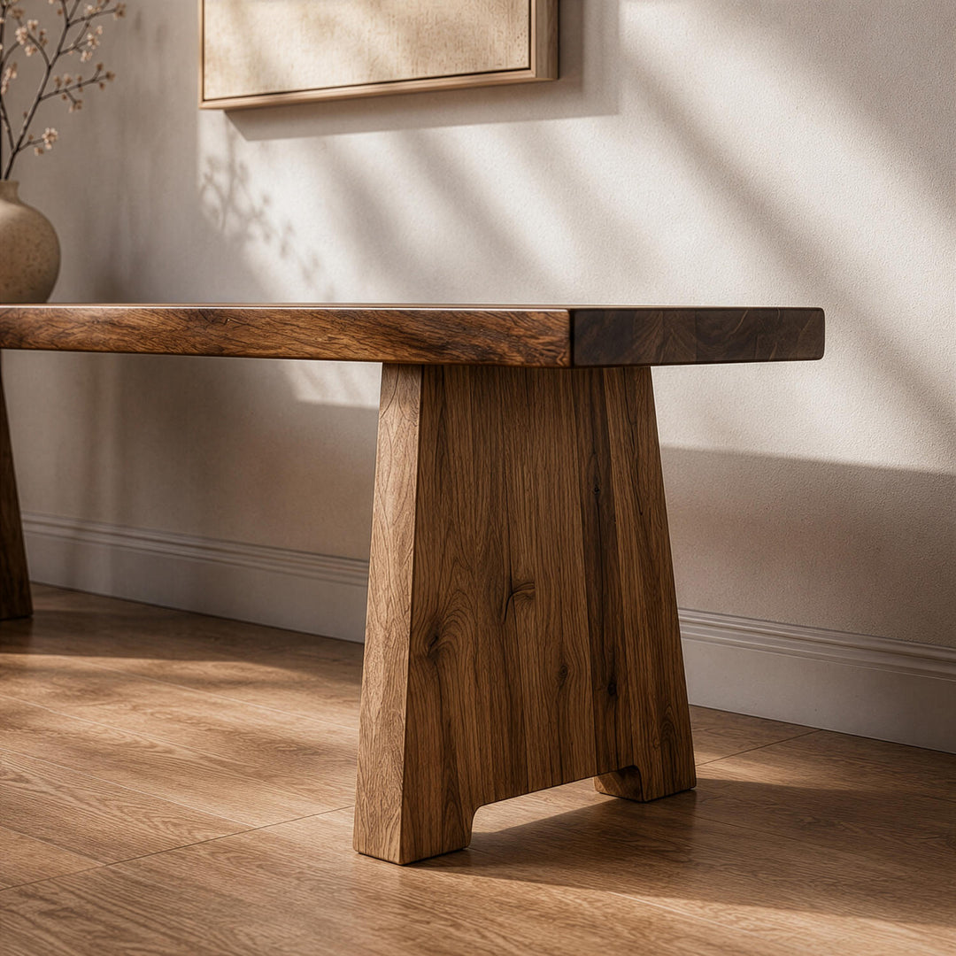 Contemporary walnut wood bench featuring block-style legs, positioned against a wall capturing soft daylight shadows.