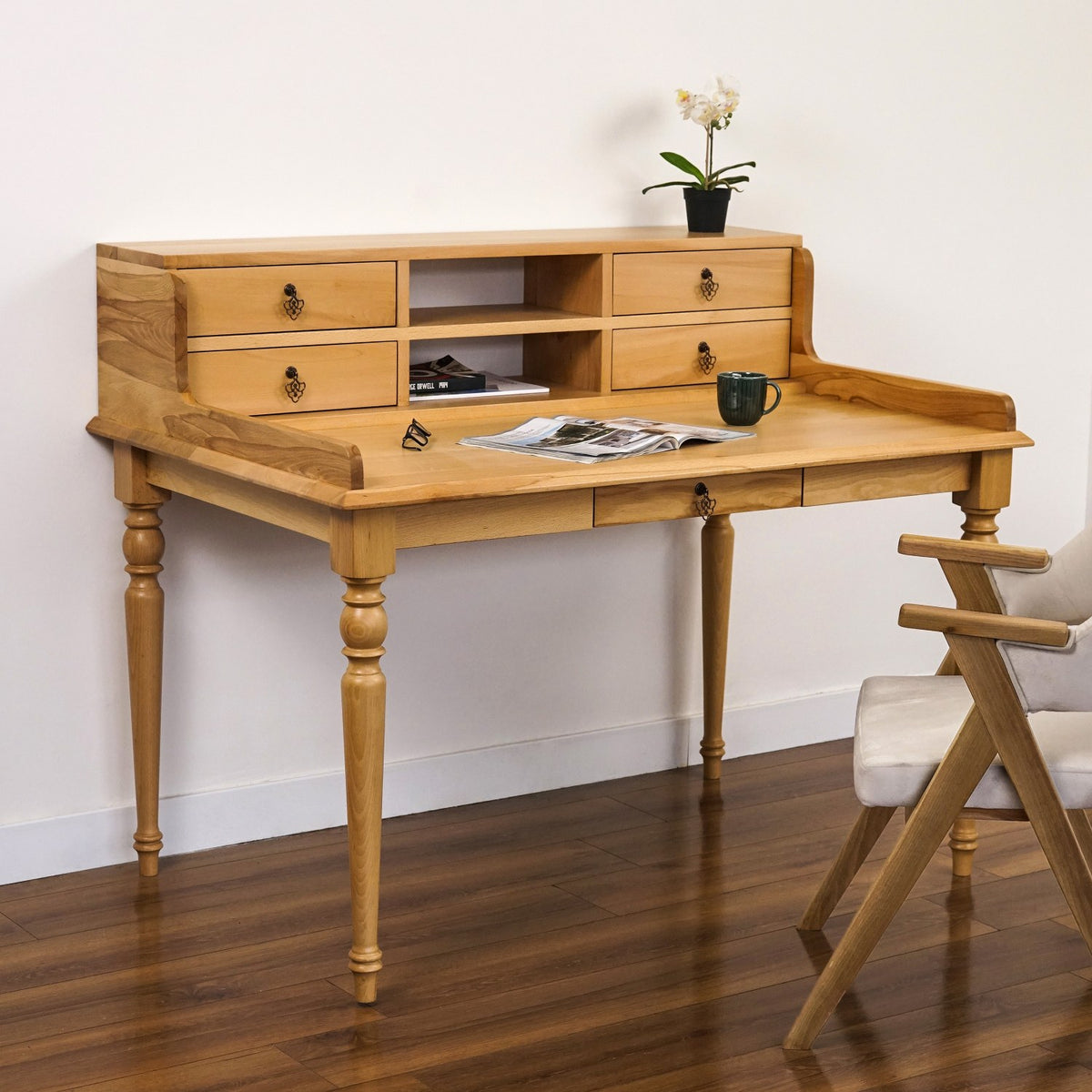 Beech writing desk with hutch drawers and a raised back edge, three-quarter view with a magazine on the desktop