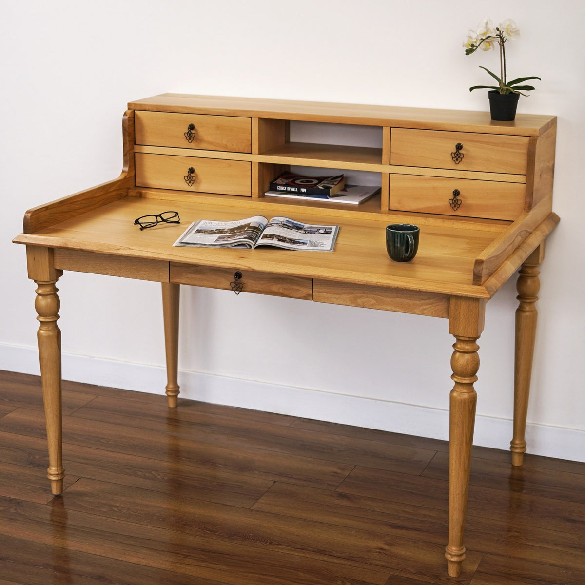 Front view of the solid beech writing desk with four hutch drawers, an open shelf and turned legs