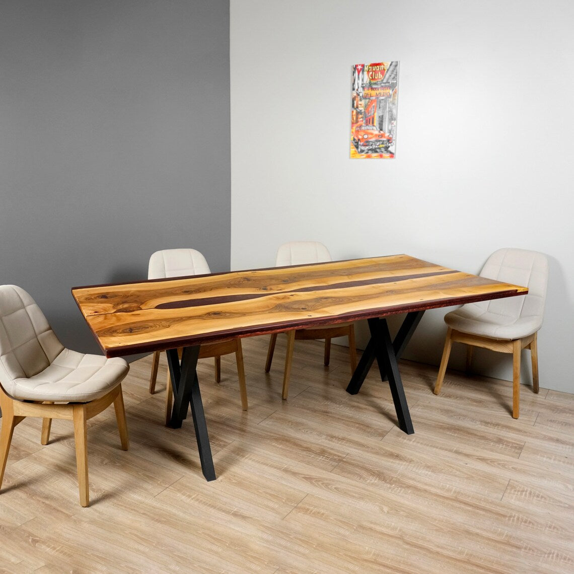 Wide view of the walnut dining table with burgundy epoxy river and four chairs in a gray room