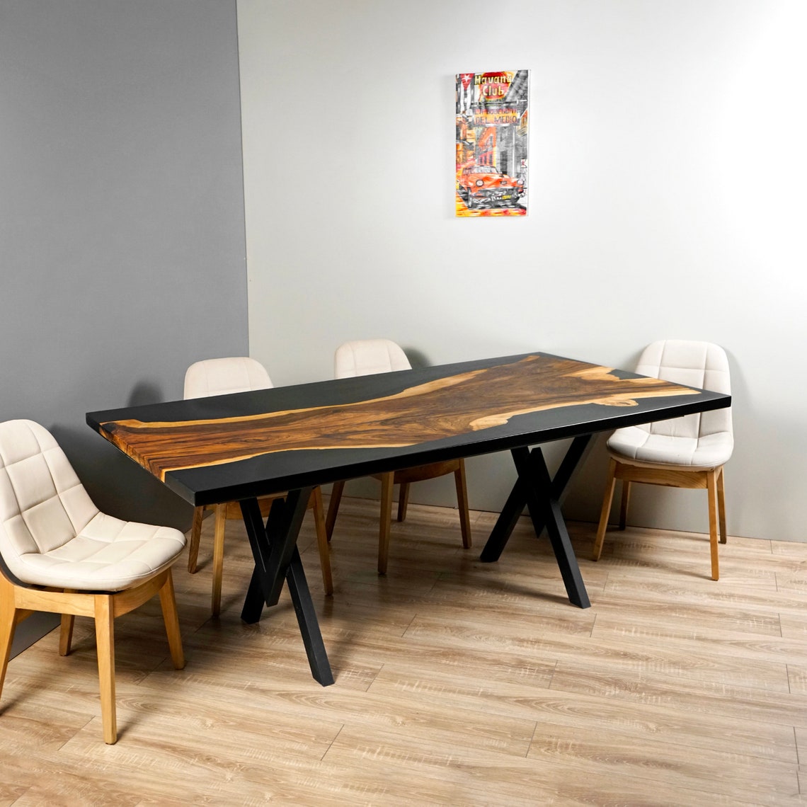 Front view of the black epoxy walnut live edge kitchen table with chairs against a gray wall
