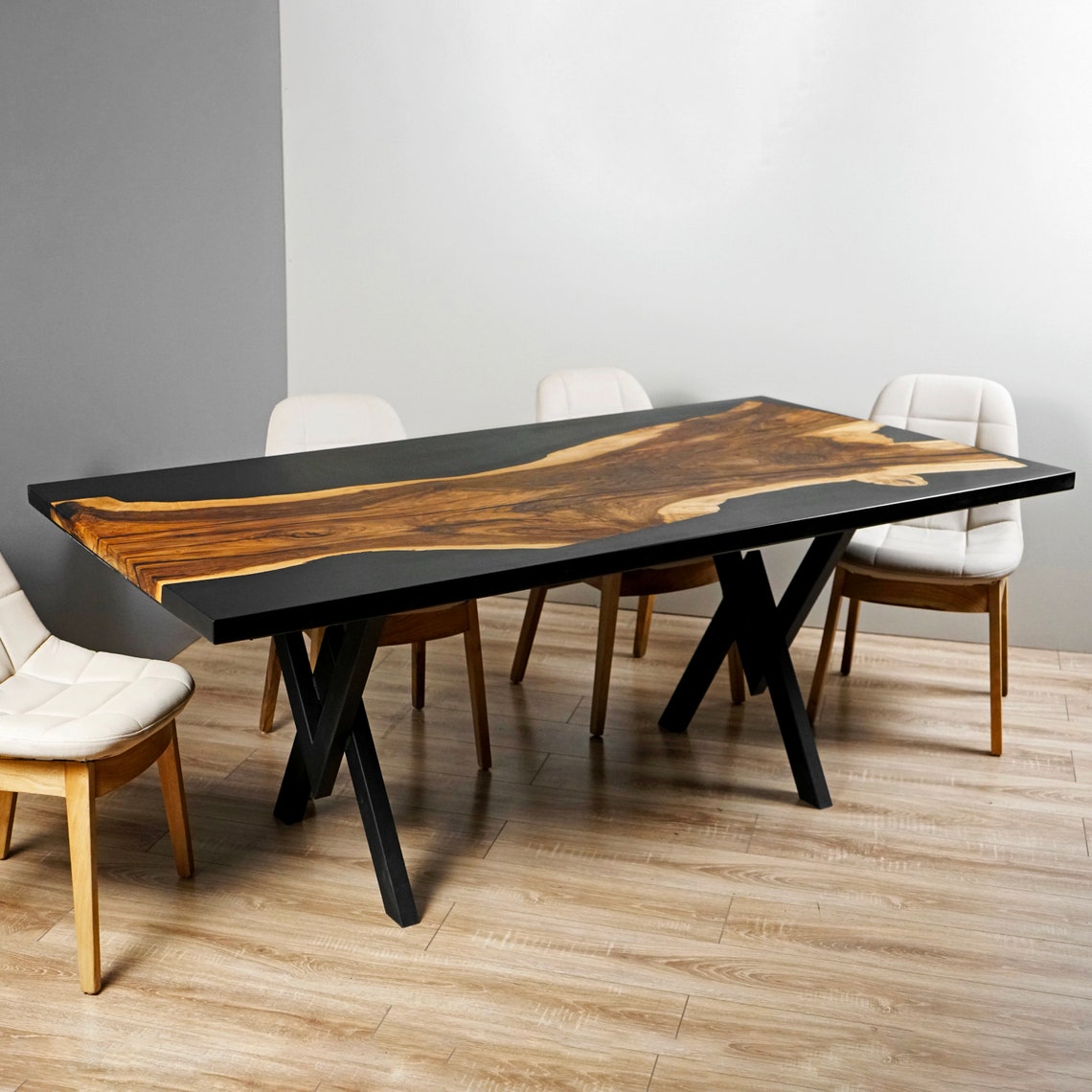 Side view of the walnut live edge kitchen table with black epoxy top and double X legs