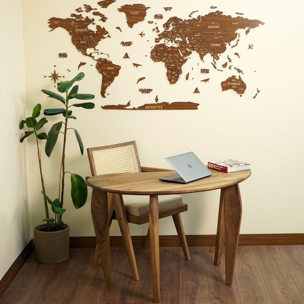Bean shaped walnut desk in a home office corner under a wooden world map on the wall