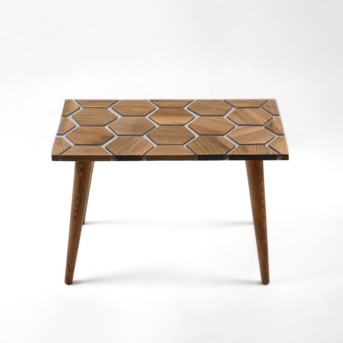 Side view of the walnut epoxy coffee table with honeycomb top and slanted tapered legs