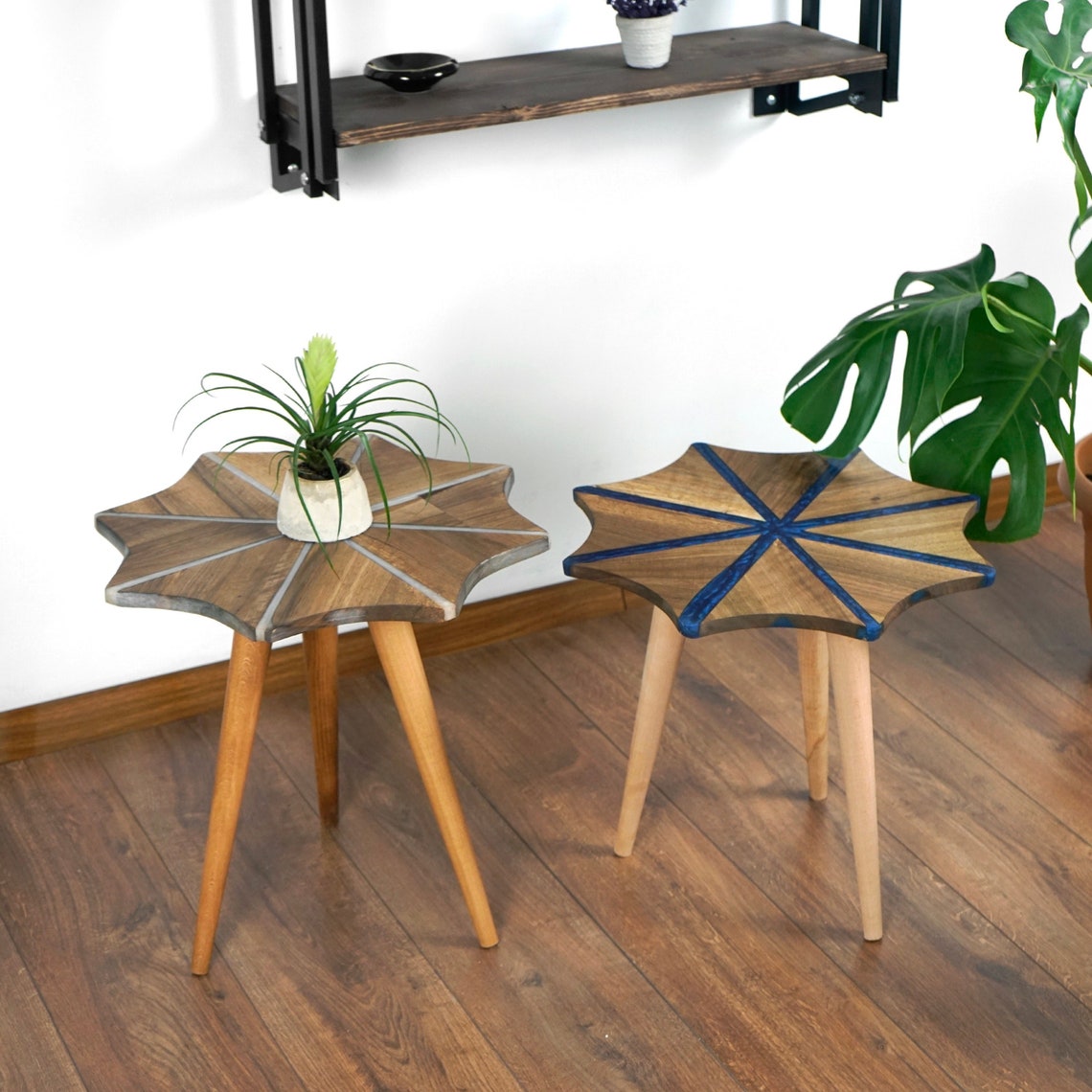 Nest of two snowflake side tables, white epoxy stripes on the left table and blue on the right, with a houseplant