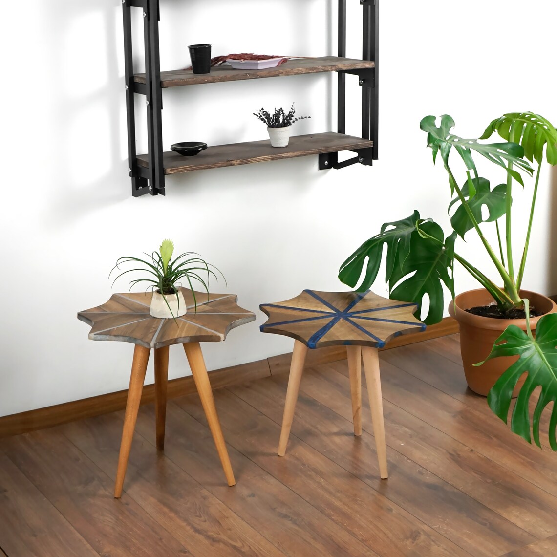 Two walnut snowflake side tables, one with white epoxy stripes and one with blue, on tripod legs